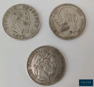 three different types of silver coins on a white surface