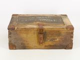 an old wooden box with writing on it sitting on a white surface