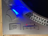 a close up of a turntable with a blue light on it