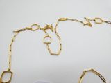 deux bijoux en or posés sur une surface blanche, sur fond blanc