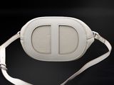 a white leather cross body bag on a black background