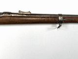 un vieux fusil accroché au mur d'une pièce