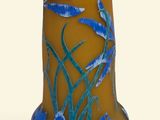 un vase sur lequel sont peintes des fleurs bleues sur fond blanc