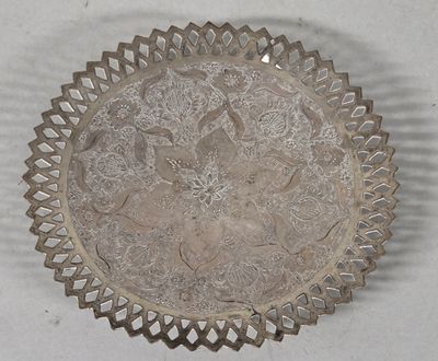 a silver plate with a design on it on a table