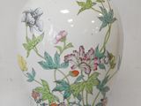 a white vase with a floral design on it