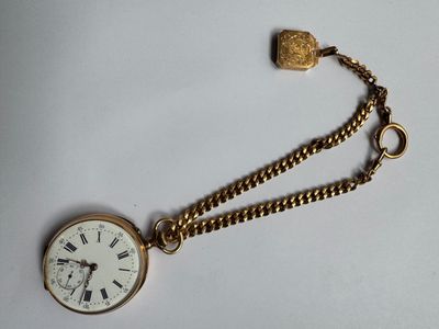 a gold pocket watch with a chain on a white surface