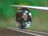 un gros plan d'un diamant tenu par une paire de pinces