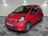 a picture of a red smart car parked in a garage