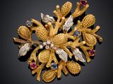 une image représentant une broche en or ornée de fleurs et de feuilles