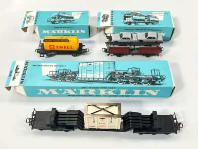 Plusieurs petits trains jouets sont posés les uns à côté des autres sur une surface blanche