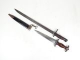 pair of two knives on a white surface with a knife in the middle