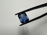 a close up of a pair of tongs holding a blue sapphire