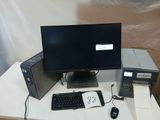 un écran d'ordinateur, un clavier et une souris posés sur une table