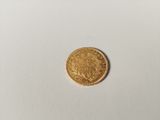 a close up of a gold coin on a white surface