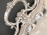 an antique silver plate with a decorative design on top of it