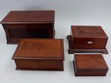 four pieces of wooden boxes with carvings on them on a white surface