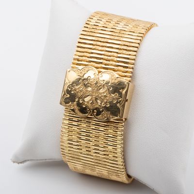 yellow gold plated bracelet on a white pillow on a white surface