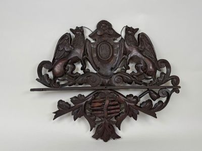 une tenture murale en bois ornée d'un blason et de deux lions