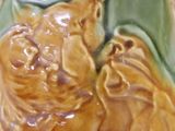 a ceramic vase with a green and yellow design on it