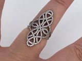 the woman ' s hand is holding a silver ring with diamonds on it