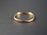 gros plan d'une bague en or sur une surface noire