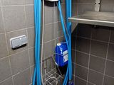 a blue hose attached to a wall in a bathroom
