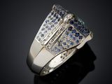 a close up of a diamond and sapphire ring on a black surface