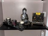 une petite étagère sur laquelle trône une statue de Bouddha