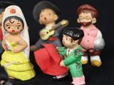 many figurines of different people on a black background