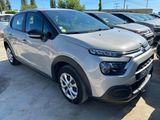 une Citroën argentée garée sur un parking à côté d'autres voitures
