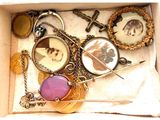 une boîte contenant divers objets, notamment un collier, des broches et d'autres articles