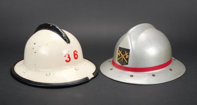deux casques de pompier posés l'un à côté de l'autre sur une table