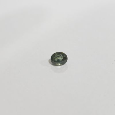 a green tourmaline gemstone on a white surface