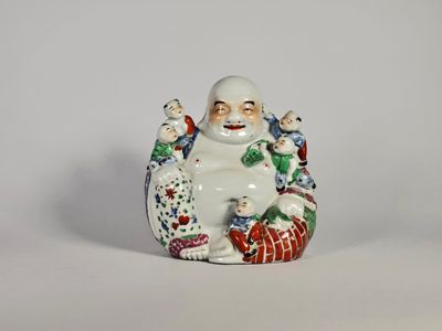 une petite figurine représentant un homme assis sur un oreiller