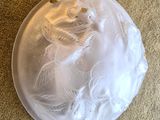 a white plate with feathers on it sitting on the floor