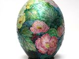 a colorful vase with flowers painted on it on a white surface