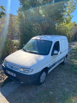 a white van parked on the side of a dirt road