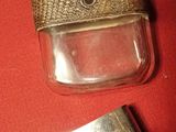 silver flaskt and lighter on a red cloth with a red background