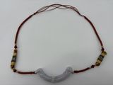 une photo d'un collier composé de perles de verre et d'un fil rouge