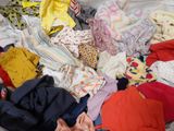 a pile of clothes that is on a bed