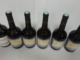 six bottles of wine are lined up in a row on a table