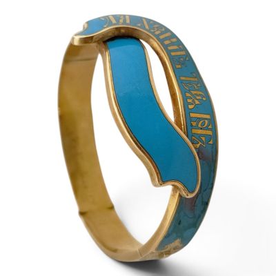 une image représentant une bague bleue et dorée ornée d'une vague