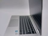 a silver laptop with a black keyboard on a white surface