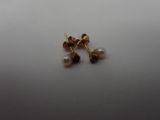 a close up of a pair of earrings on a white surface