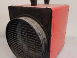 a red and black heater sitting on a white surface