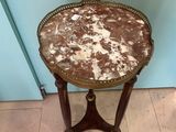 a small table with a marble top on a tile floor