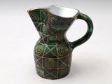 a green and brown pitcher on a white surface