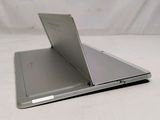 a silver laptop sitting on top of a white table