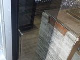 une photo d'un réfrigérateur dans un magasin, avec des verres à vin sur les étagères