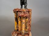 statue of a lion on a pedestal with a marble base
